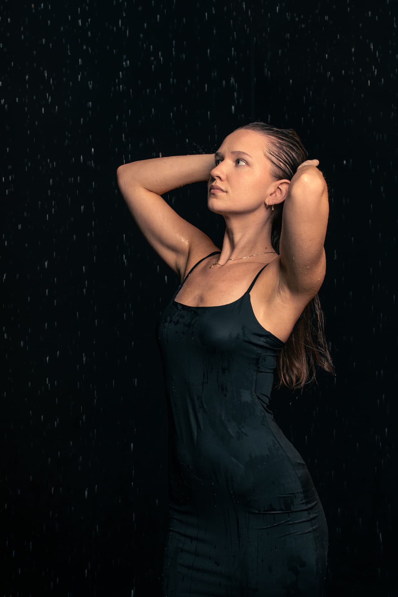 Rain Room — portret w czerni pod strumieniem deszczu